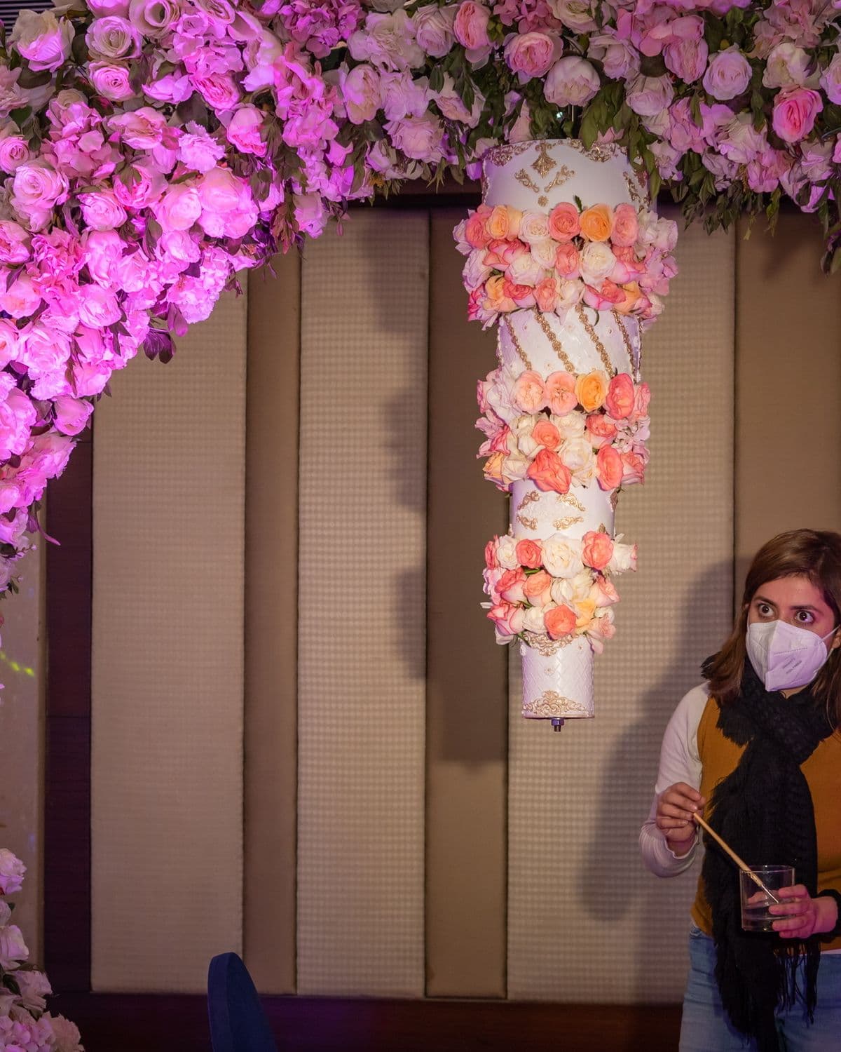 A floral arch and a cake suspende…