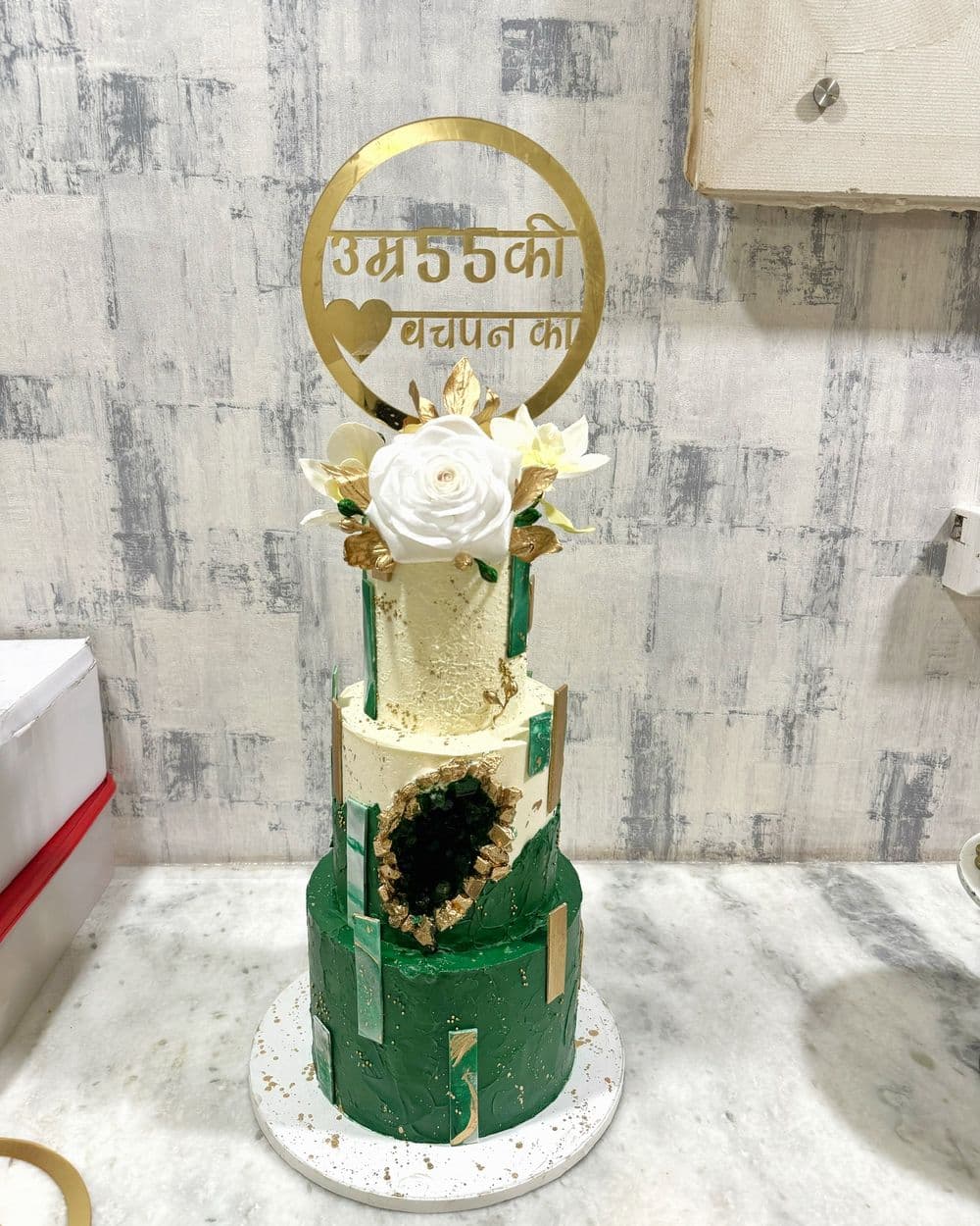 Emerald and gold tiered cake with a milestone topper