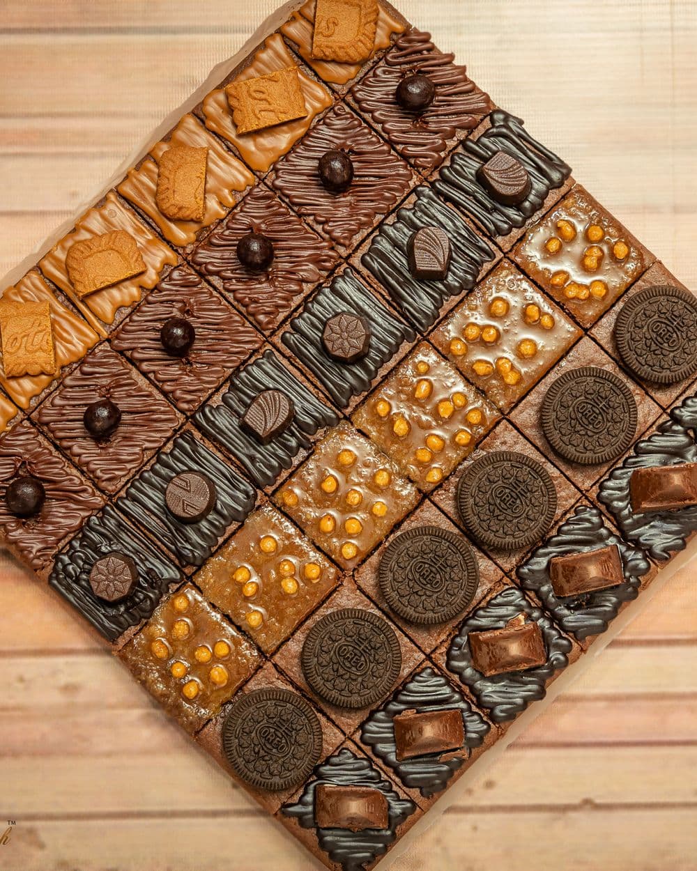 Wooden board laid with rows of assorted desserts and bakes