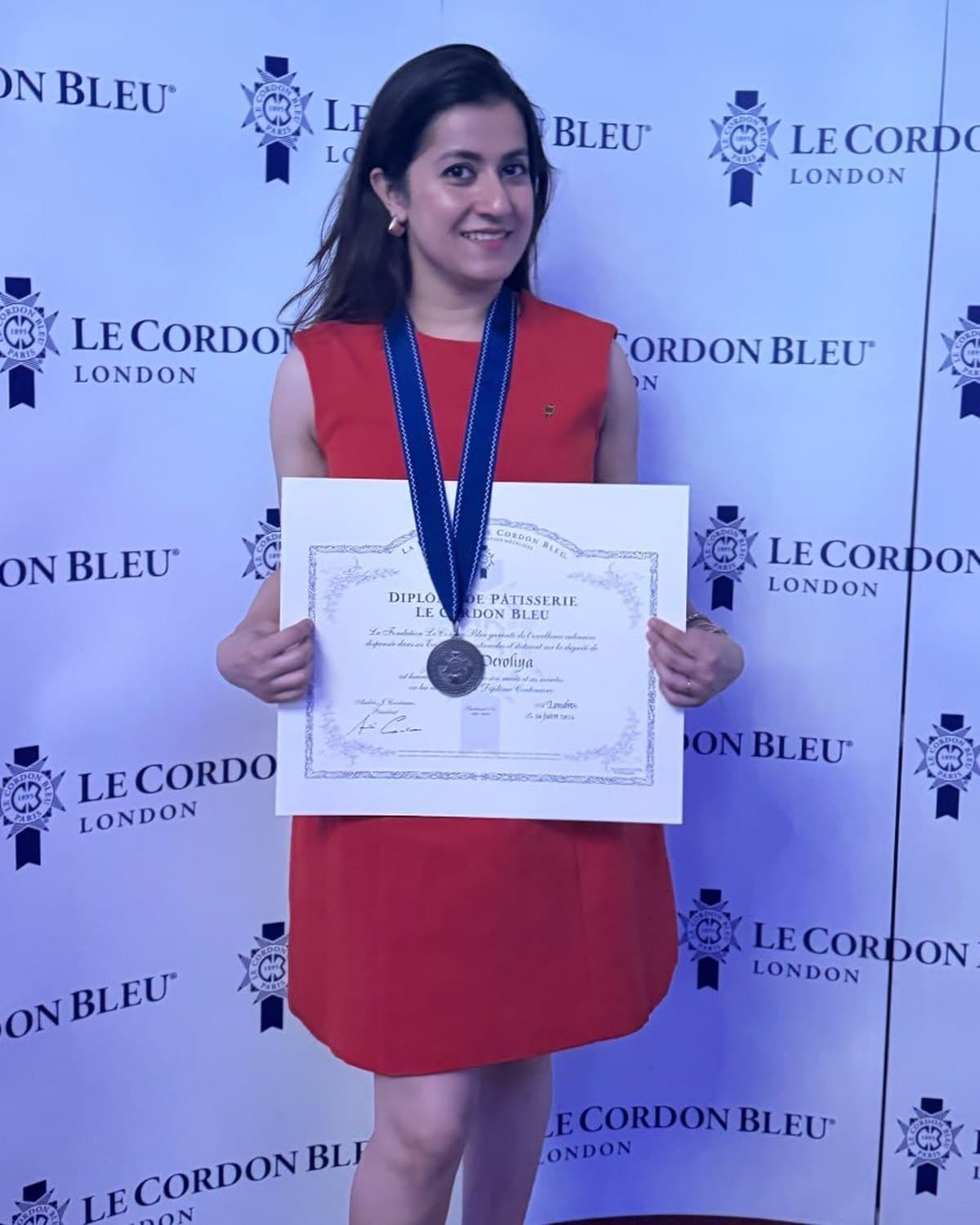 Swati Deroliya at Le Cordon Bleu London, wearing her medal and holding the Diplôme de Pâtisserie
